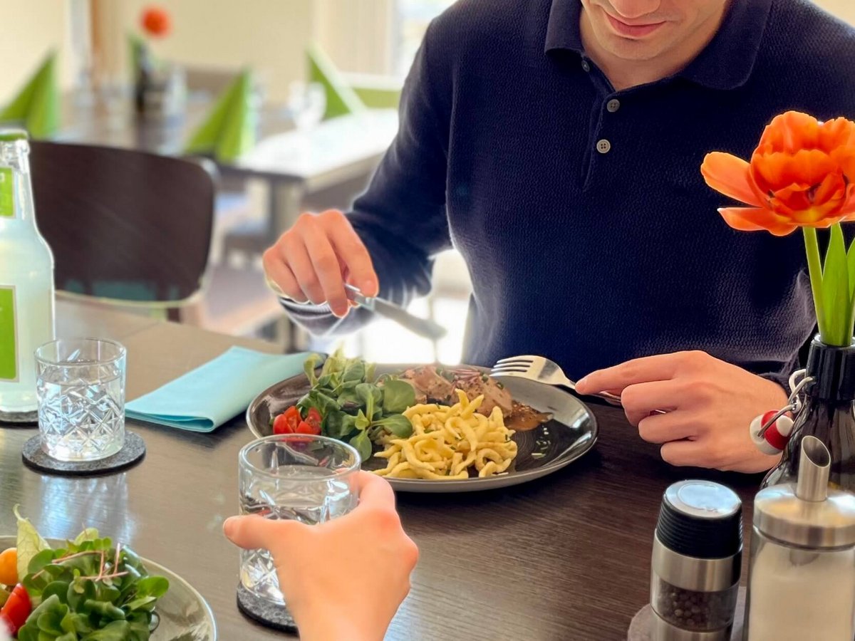 Zwei Menschen sitzen am Tisch und essen