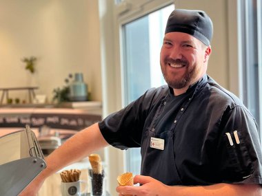 Ein Koch macht ein Eis an der Eistruhe