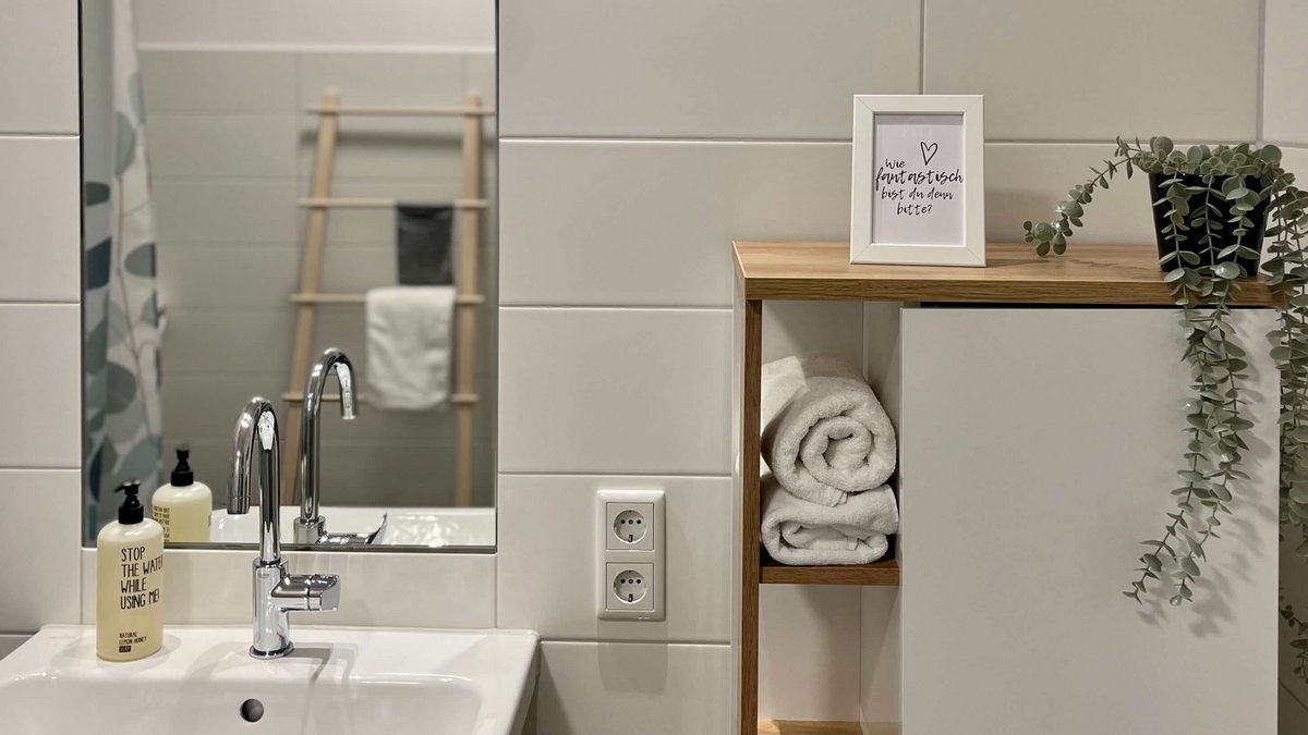 Badezimmer mit Spiegel, Waschbecken und Regal 