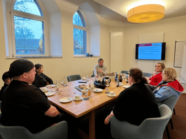 Eine Gruppe sitzt im Tagungsraum Edessa