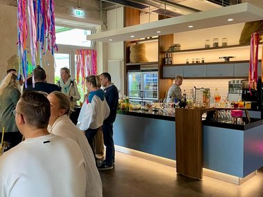 Menschen in einem Raum, die Cocktails trinken